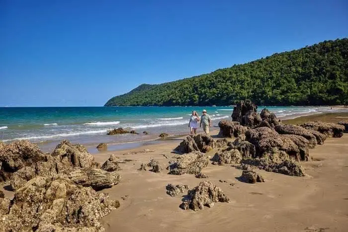 Etty Bay beach with rainforest-covered headland and coastal rocks