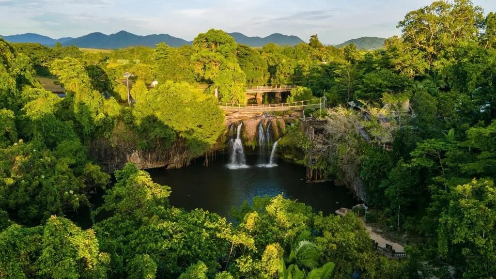 Aerial view of Paronella Park castle and Mena Creek Falls surrounded by rainforest