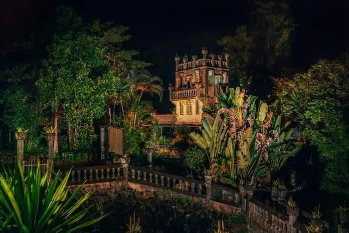 Paronella Park castle ruins illuminated at night during the evening light show