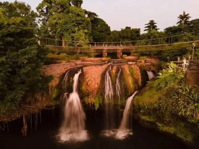 Mena Creek waterfalls illuminated at dusk at Paronella Park