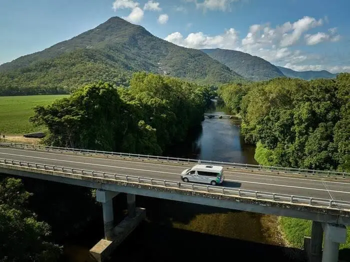 Tropic Tours vehicle crossing a bridge on the journey from Cairns to Paronella Park